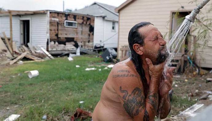 Un hombre den una ducha al aire libre después de los huracanes que asolaron el sur de EEUU
