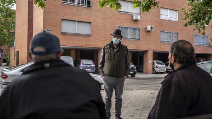 Un grupo de hombres conversa en un banco en el barrio de Orcasur. Olmo Calvo