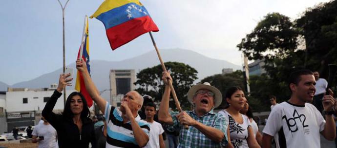 Simpatizantes del presidente interino Juan Guaidó ondean banderas este martes en la base militar La Carlota