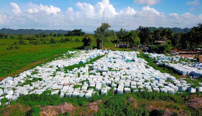 Miles de botellas de agua donadas, aparecen en una finca