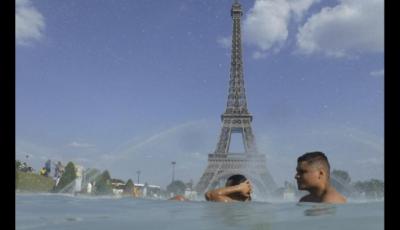 n grupo de personas se refresca en una fuente en París, Francia. 