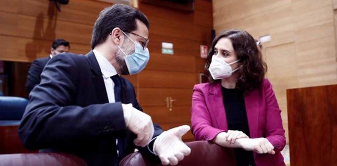 La presidenta de la Comunidad de Madrid, Isabel Díaz Ayuso (d) conversa con el consejero de Hacienda, Javier Fernández-Lasquetty (i) antes del comienzo de la sesión de control al ejecutivo regional en la Asamblea de Madrid. 