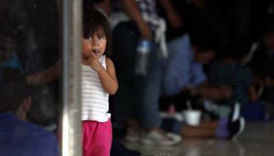 Una niña migrante, cuya familia espera llegar a Estados Unidos, mira a la cámara mientras sus padres esperan en un centro de inmigración en México. 