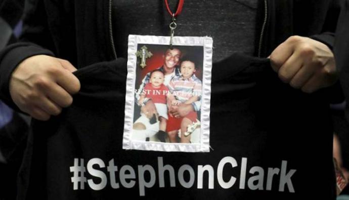 Una persona sostiene una fotografía de Stephon Clark durante su funeral. 