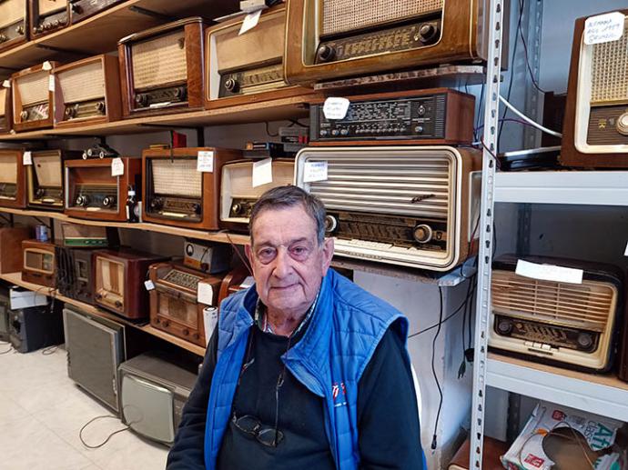 Román Barona ante su colección de aparatos de radio y televisión