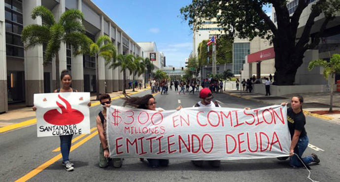 Un grupo de estudiantes sostiene una pancarta contra el Banco Santander en San Juan, Puerto Rico