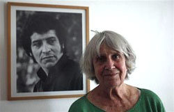 Joan Turner, viuda de Víctor Jara, con un retrato del cantante al fondo

