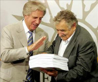 
El presidente uruguayo, Tabaré Vázquez (i), entrega a su futuro sucesor, José Mujica (d), informes para agilizar las labores de transición de gobierno. 
