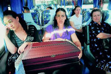 Familiares de un desaparecido cuyo cuerpo fue hallado en una fosa común llevan sus restos en autocar. -