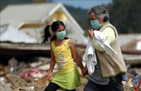 Una mujer y una niña caminan en medio de varios escombros en la localidad de Dichato, al sur de Chile