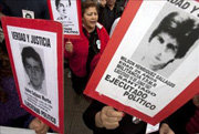 Familiares de detenidos desaparecidos portan carteles con la imagen de sus deudos 

